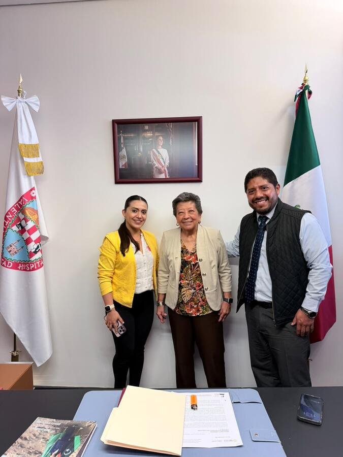 La senadora acompañada de su equipo en su oficina, con las banderas de México y Chihuahua