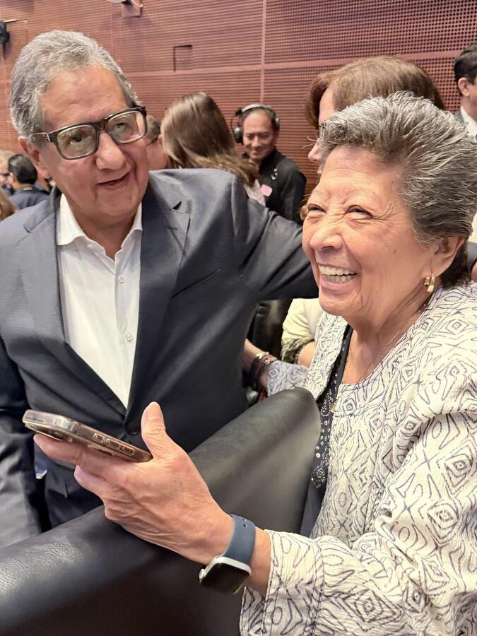 La senadora conversa con un compañero legislador en el salón de sesiones